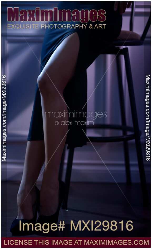 Closeup of sexy legs of woman wearing tight black skirt with high cut