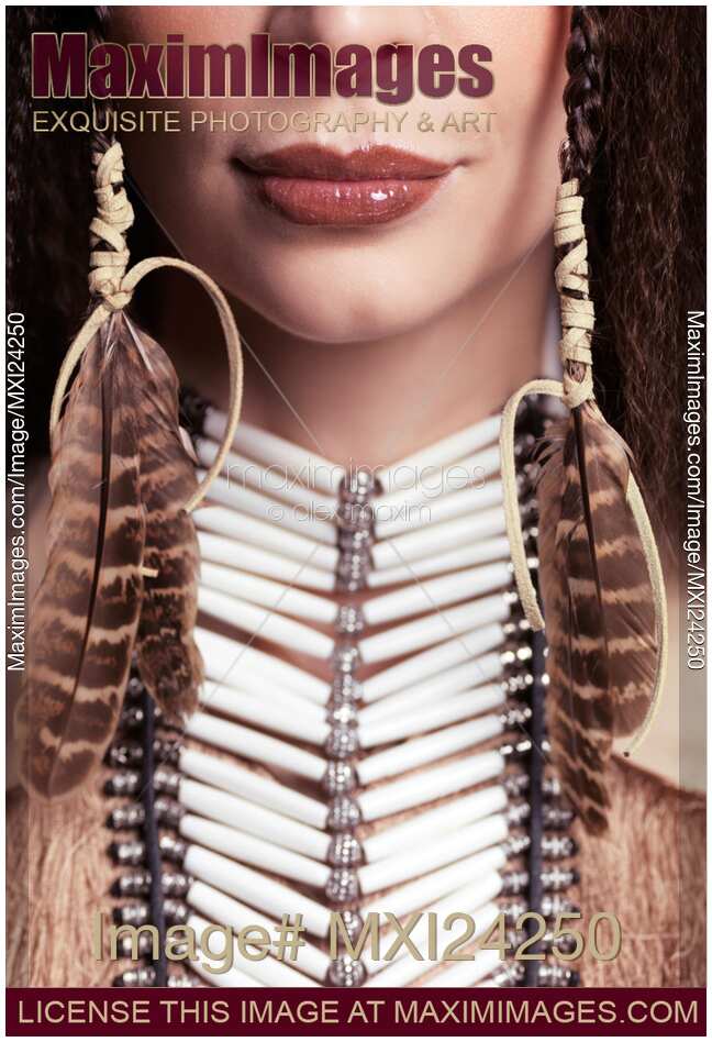 Closeup of woman wearing aboriginal necklace and feathers