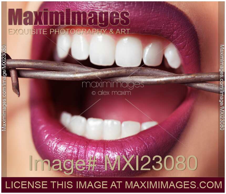 Closeup of Woman's Mouth Biting on Barbed Wire