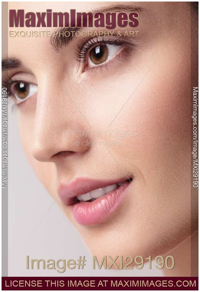 Closeup of young beautiful woman face with clean glowing skin
