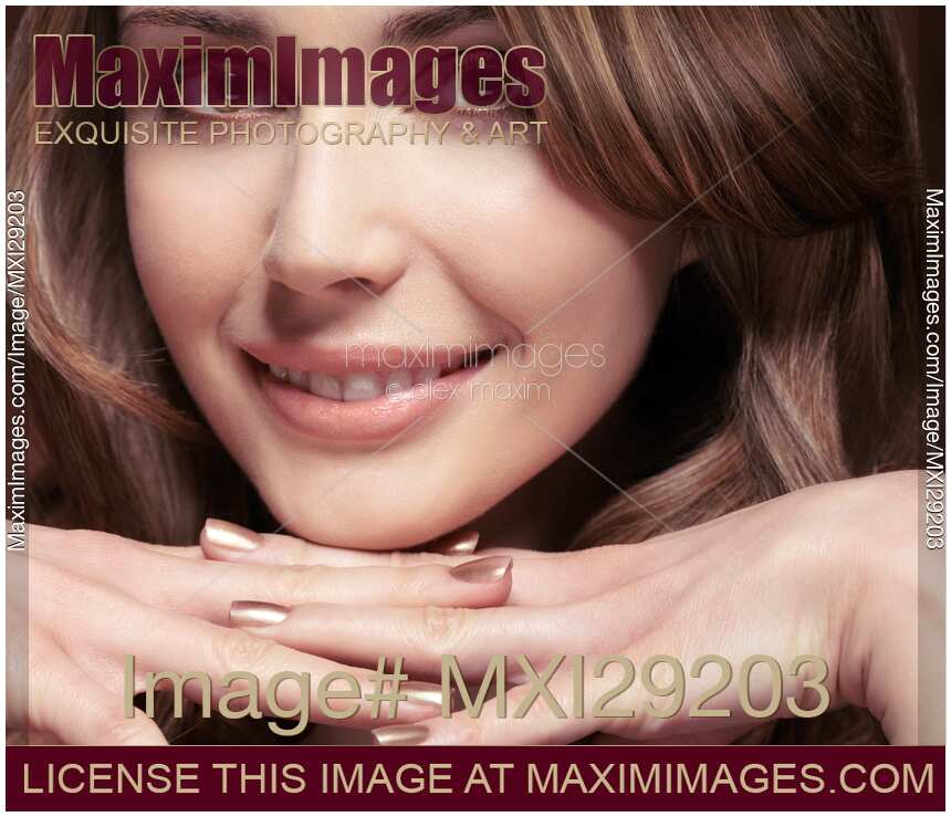 Closeup portrait of a beautiful smiling young woman resting her chin on her hands
