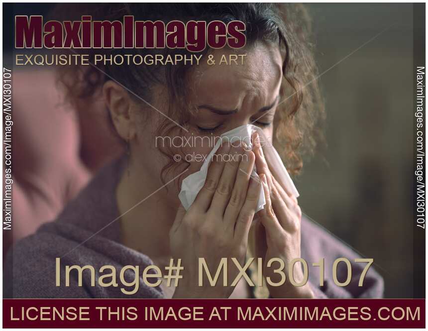 Closeup portrait of woman blowing her runny nose in paper tissue