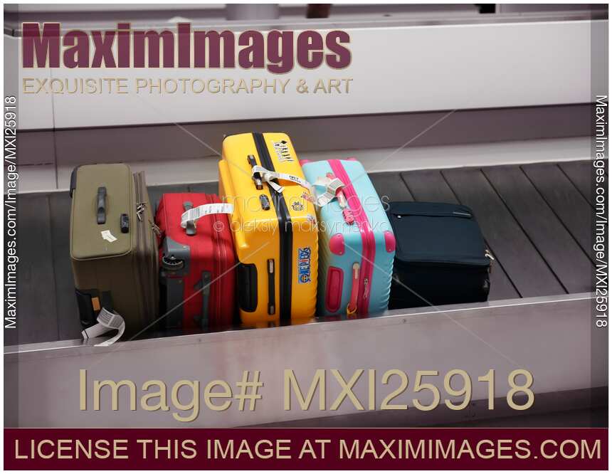 Colorful suitcases on airport baggage claim conveyor