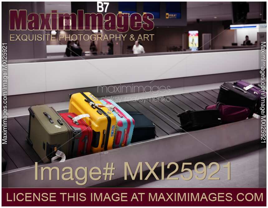 Colorful suitcases on airport baggage conveyor carousel