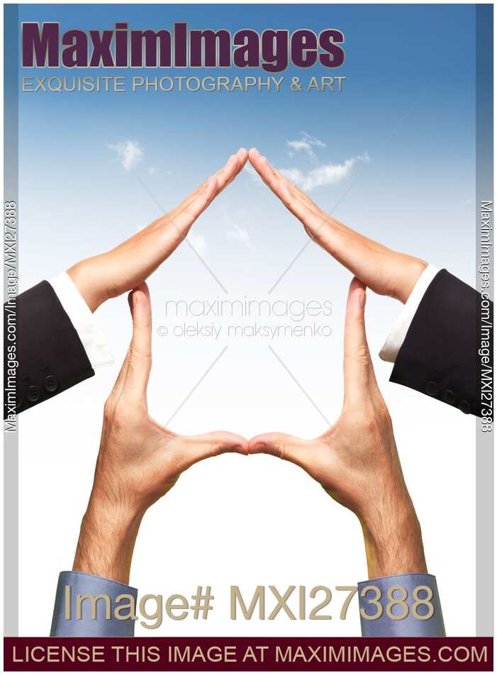 Conceptual home symbol made by hands over blue sky