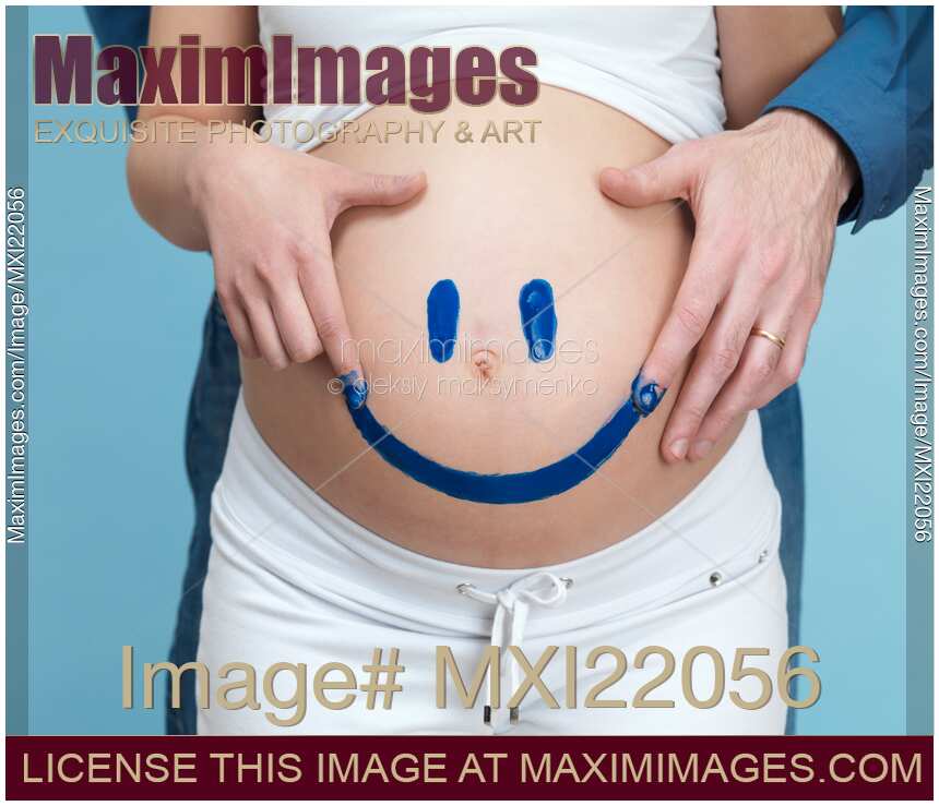 Couple Painting a Smiley on a Pregnant Woman's Belly