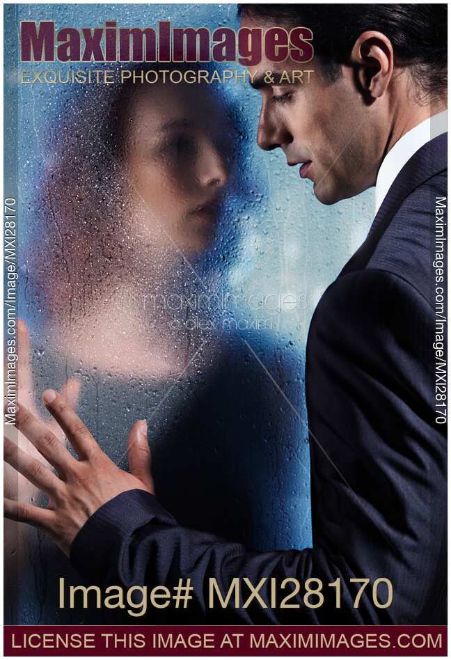 Couple separated by wet glass pane. Relationship drama romantic concept.