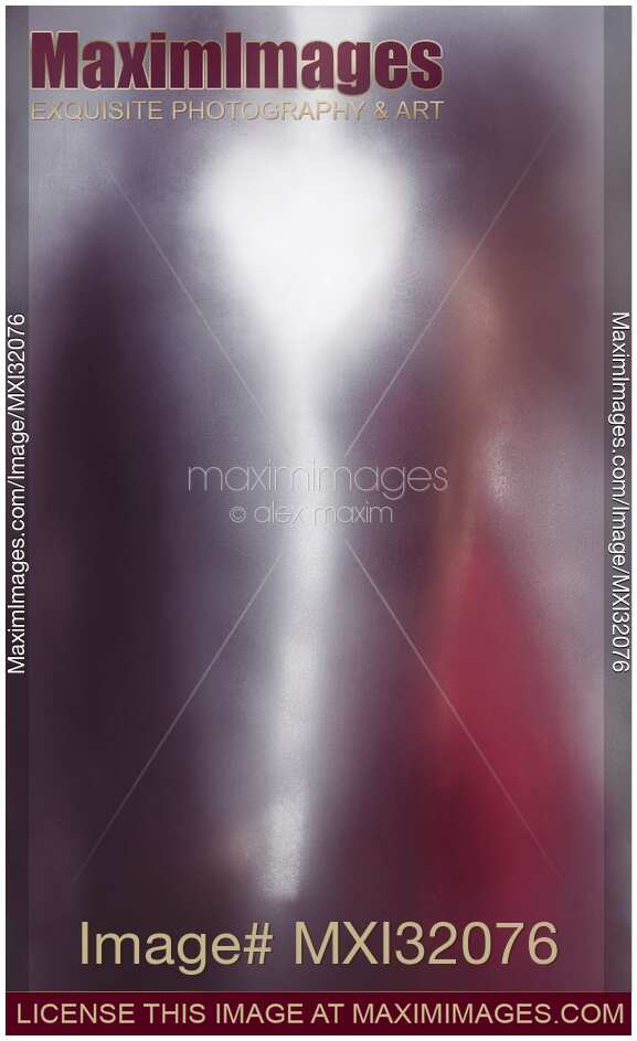 Couple standing facing each other behind hazy frosted glass with heart shaped light them
