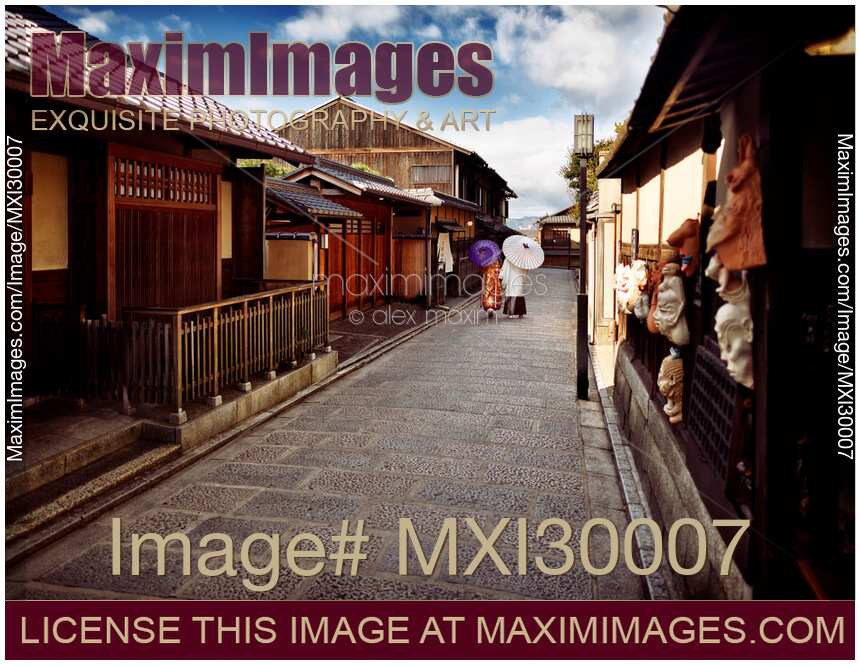 Couple with Japanese parasols in traditional kimono walking on street in Kyoto Japan