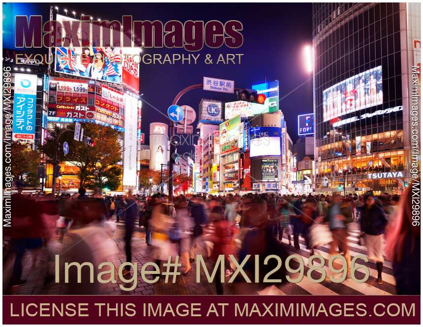 Crowded Shibuya intersection with people crossing the busy street at night Tokyo Japan
