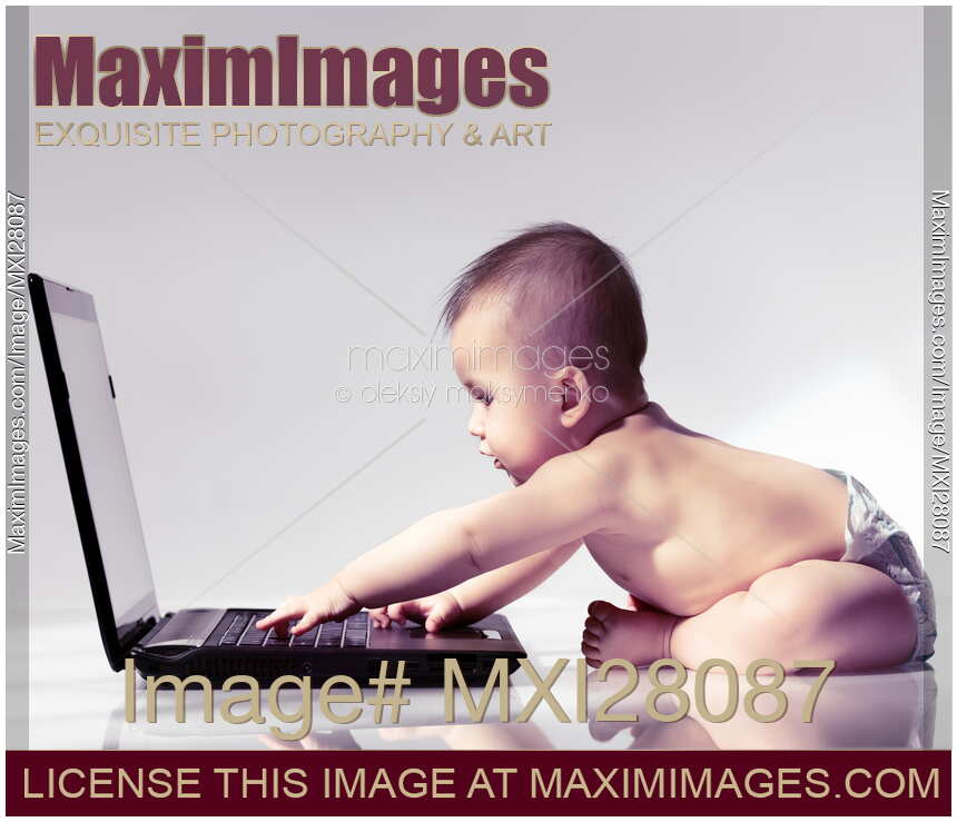 Cute baby in diaper playing with computer