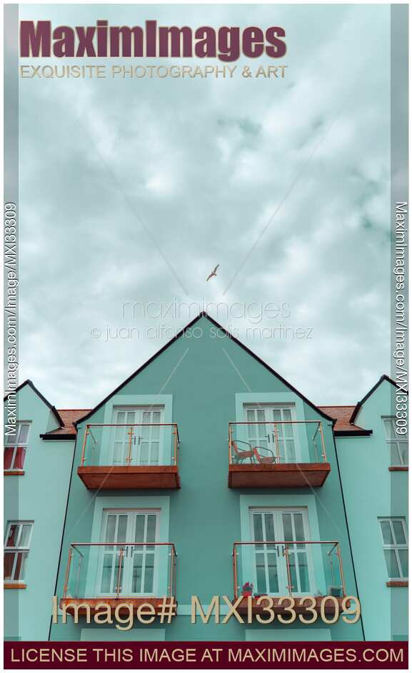 Cute blue residential houses with balconies under blue sky