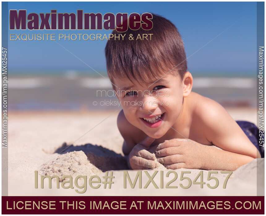 Cute little boy playing in the sand on a beach