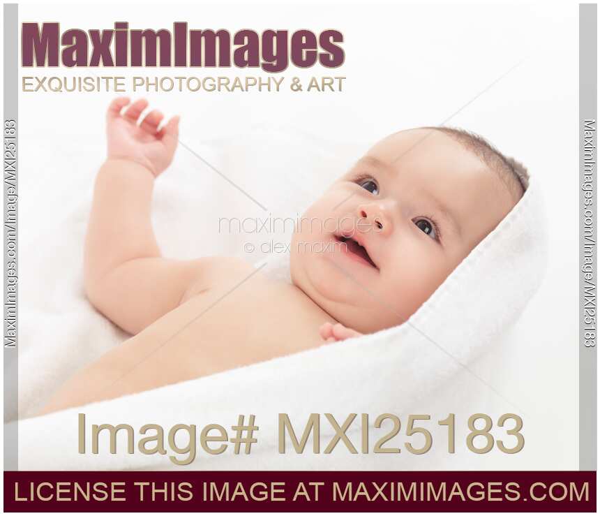 Cute smiling baby boy cuddling in towel