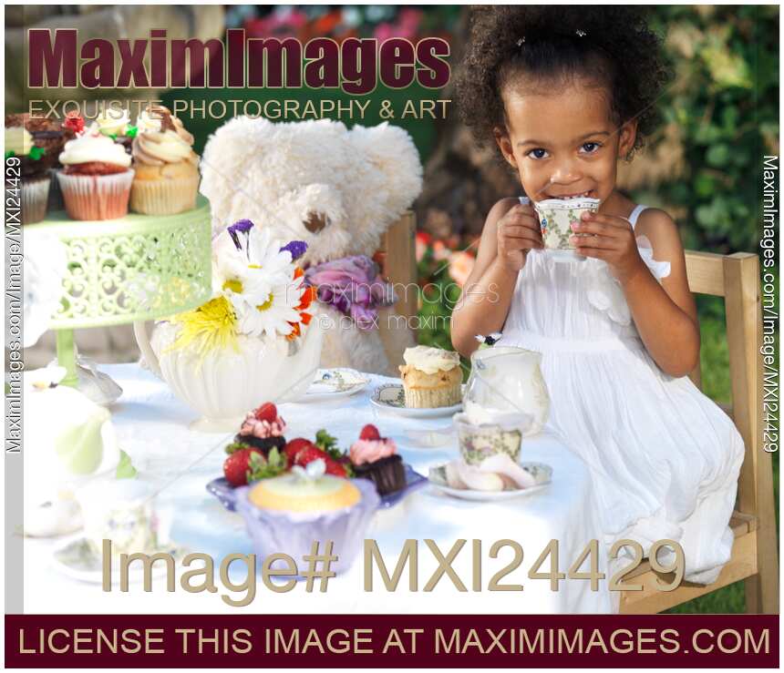 Cute smiling girl drinking tea at a party table