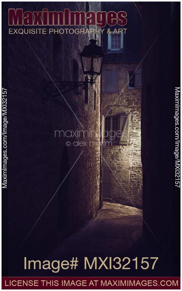 Dark old street with stone houses in a medieval French town at night