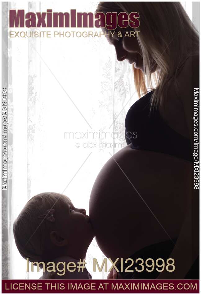 Daughter Kissing Her Pregnant Mother's Belly