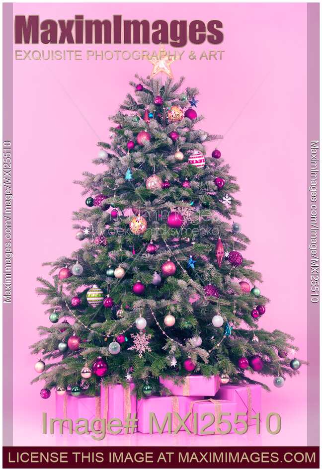 Decorated Christmas tree with presents on pink background