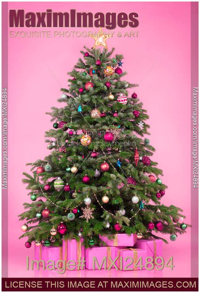 Decorated Christmas tree with presents on pink