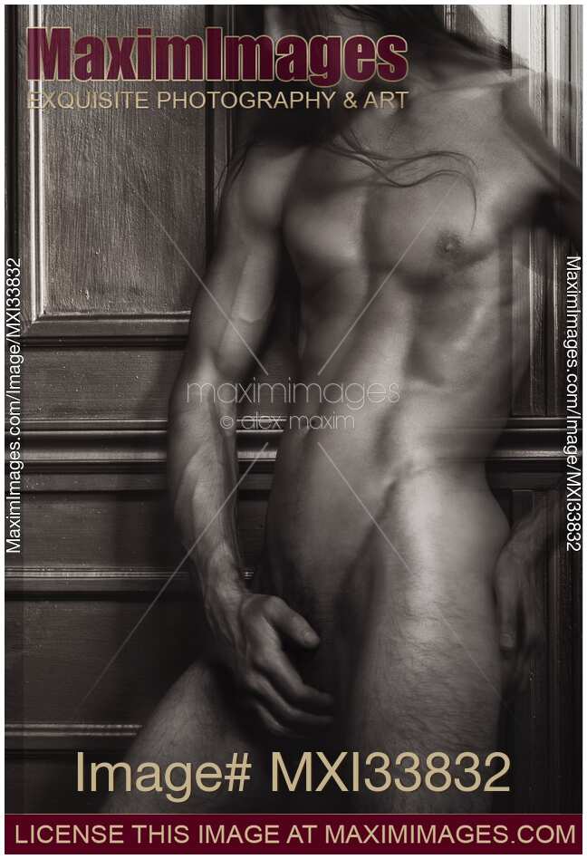 Dramatic art nude black and white portrait of nude man with shiny muscular body leaning against wall