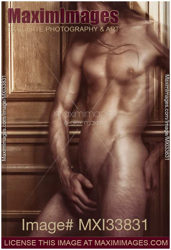 Dramatic art nude portrait of nude man with shiny muscular body leaning against golden wall