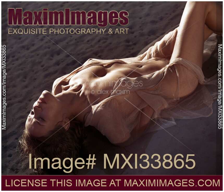 Dramatic portrait of a beautiful half-naked woman lying in water her naked body barely covered with sheer clothes