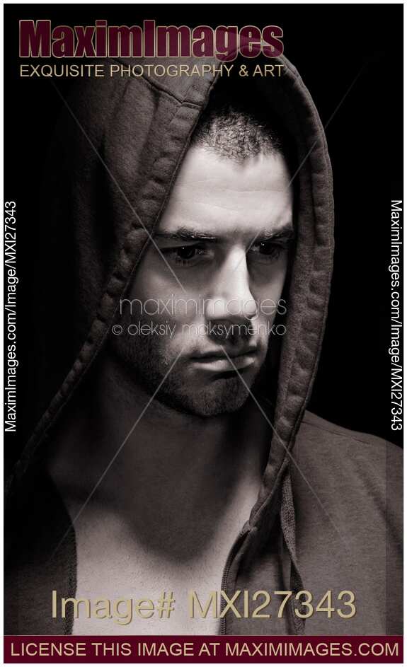 Dramatic portrait of a man in a hoodie with serious expression on his face