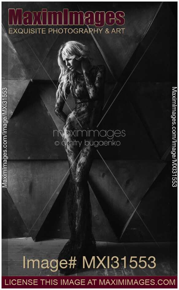 Dramatic sexy portrait of a beautiful blond woman in black lacy bodystocking dress over naked body