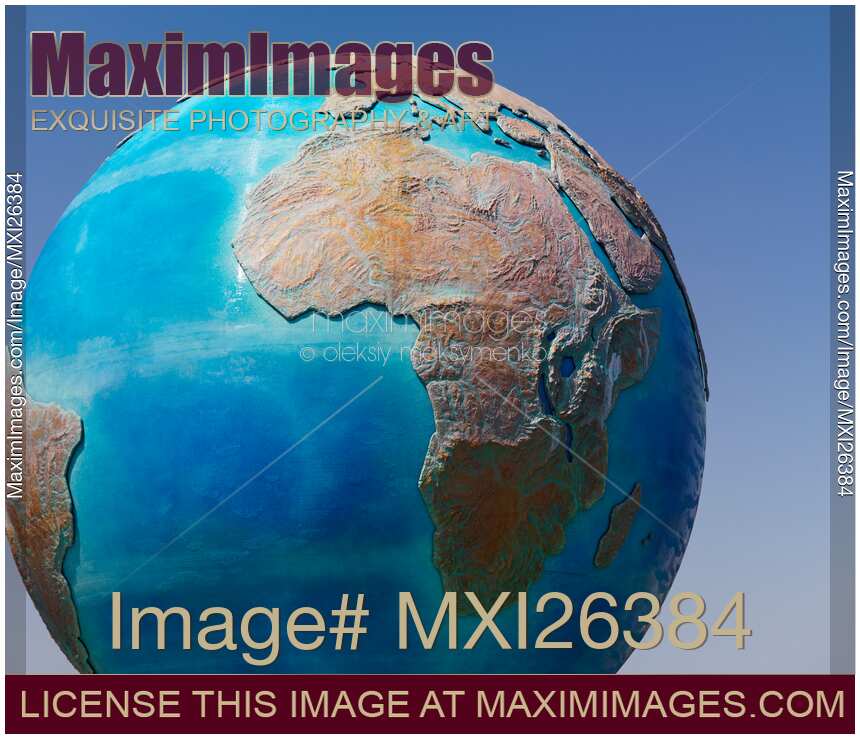 Earth globe sculpture over blue sky