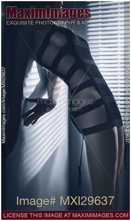 Edgy sexy fashion photo of a woman in stripy underwear in dim window light