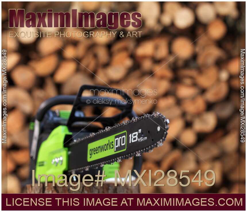 Electric Cordless Chainsaw and stacked firewood