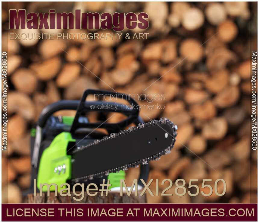 Electric Cordless Chainsaw by stacked firewood