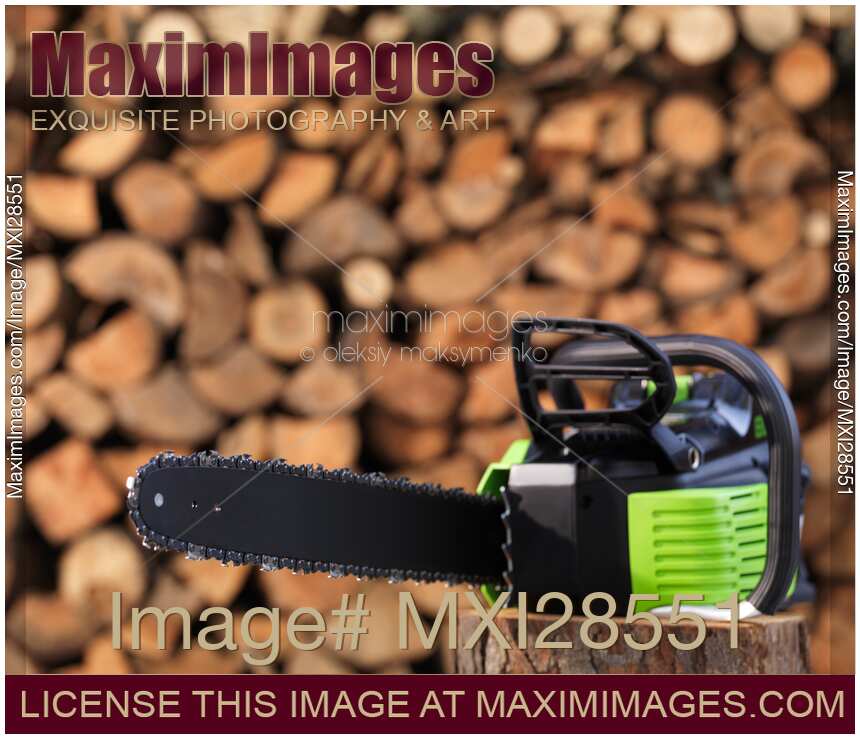 Electric Cordless Chainsaw by stacked firewood