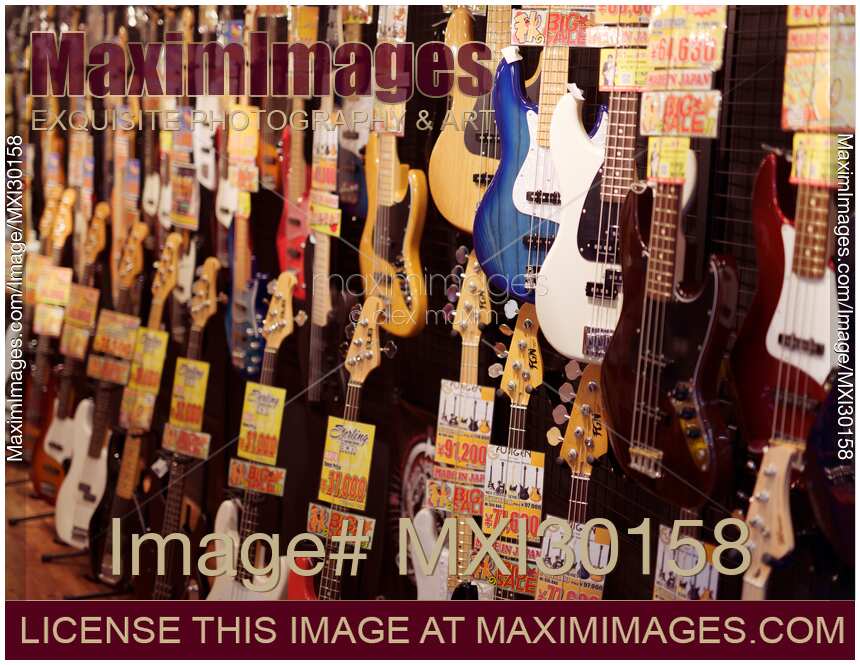 Electric guitars and bass guitars on display in a music store in Japan