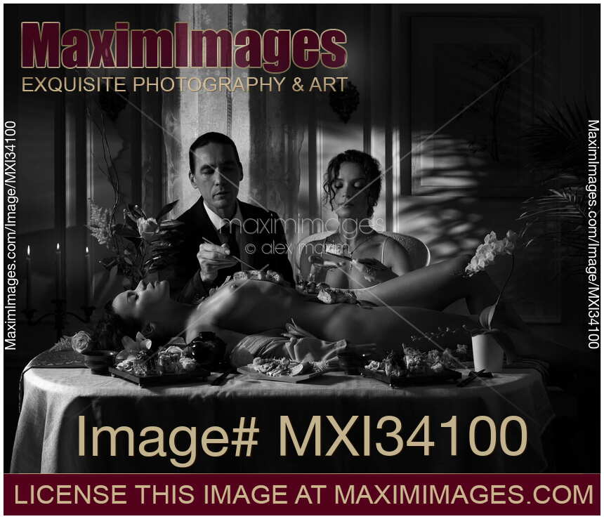 Elegant couple eating Nyotaimori sushi served on naked body of beautiful nude woman lying on table Black and white Noir