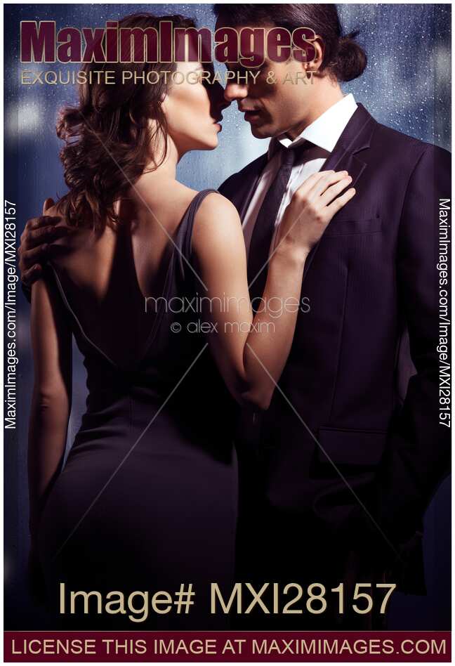Elegant couple kissing in front of window