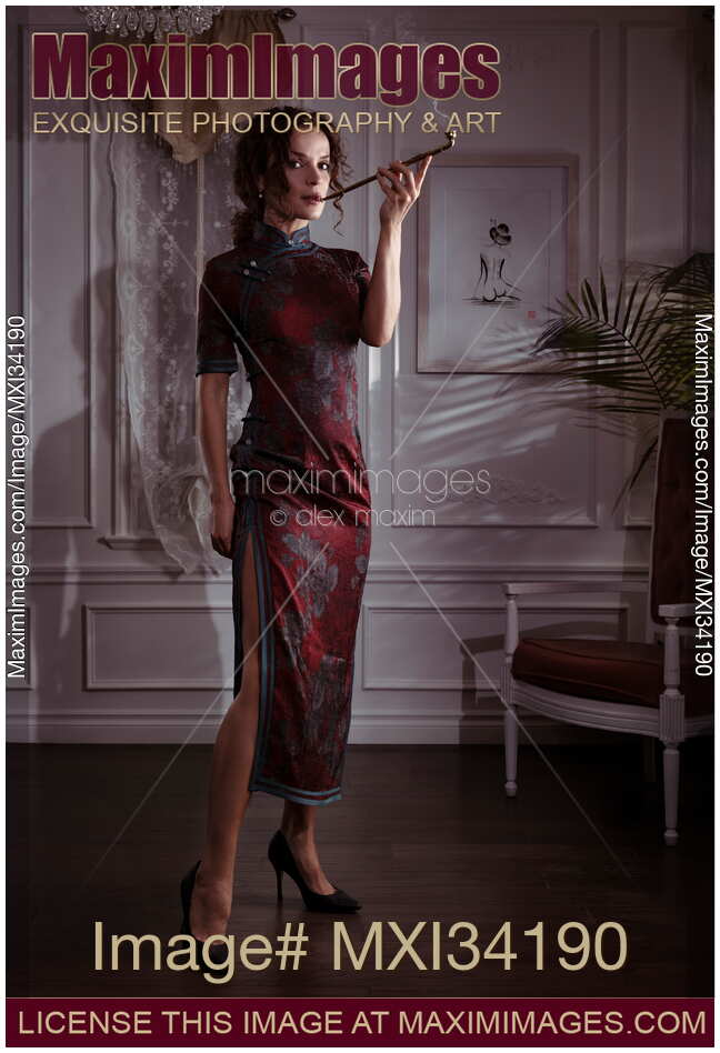 Elegant femme fatale lady in Shanghai-style Cheongsam dress standing smoking long Chinese pipe