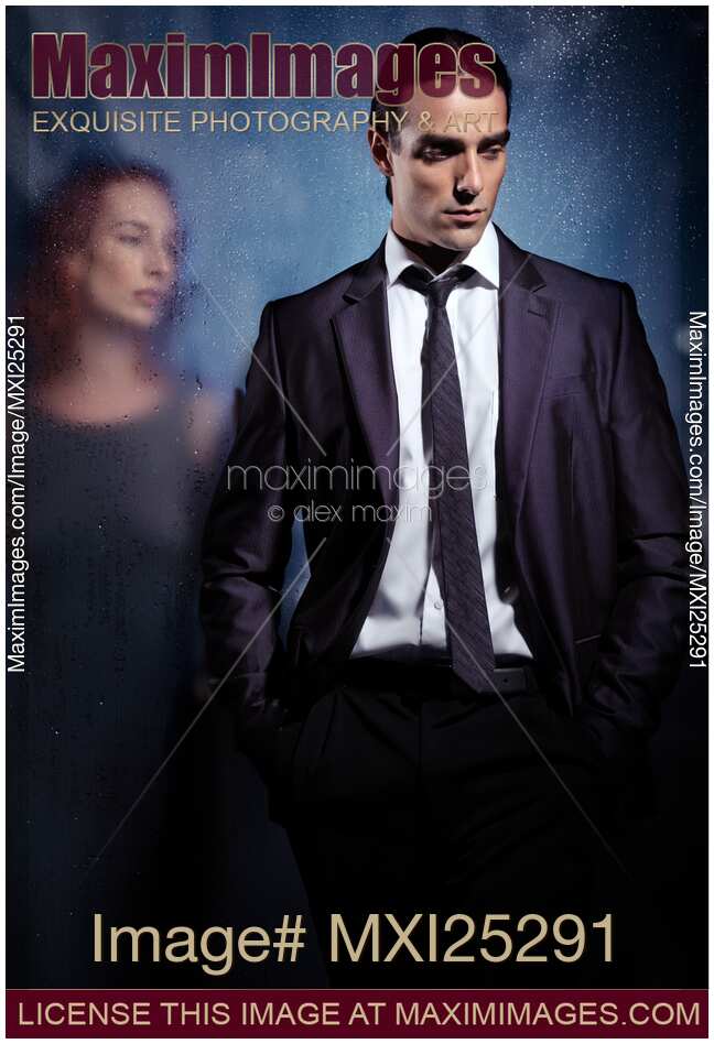 Emotional portrait of a couple separated with glass