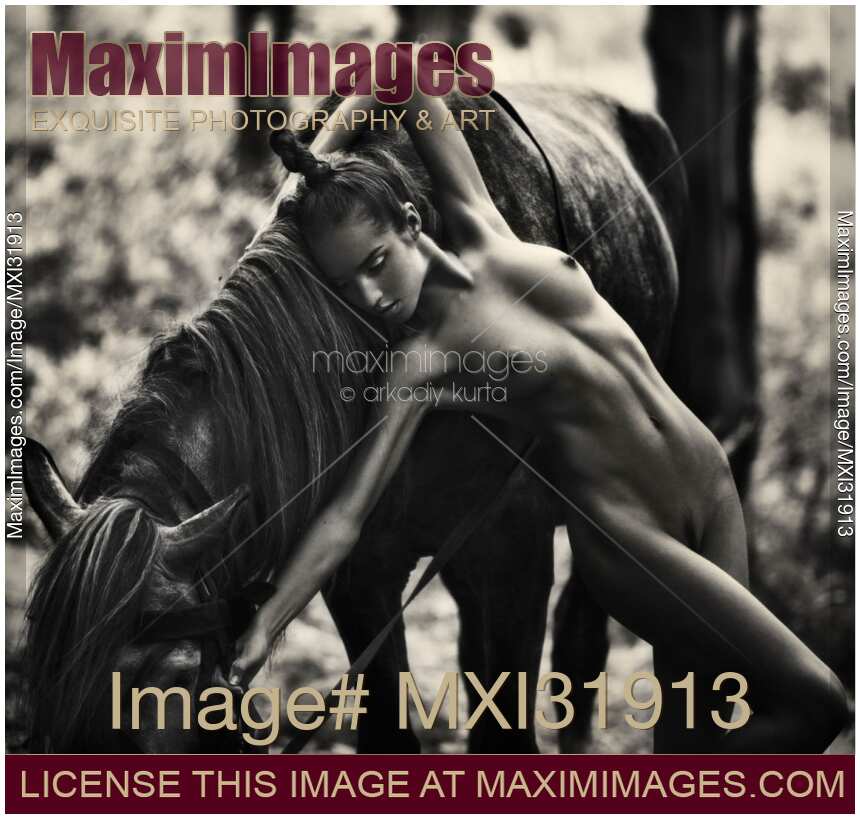 Expressive black and white fine art photo of a young naked woman with a horse