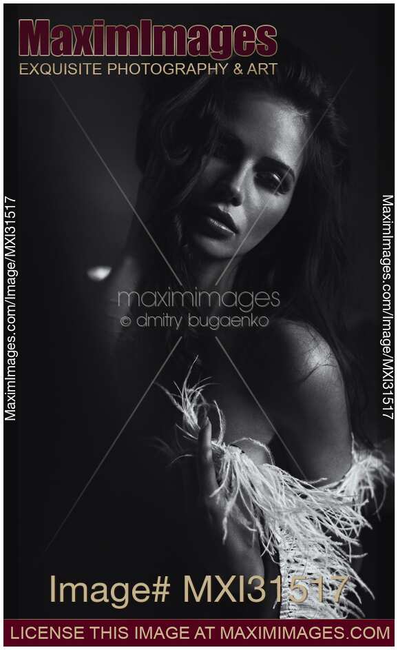 Expressive black and white portrait of a beautiful woman with feather boa around shoulders