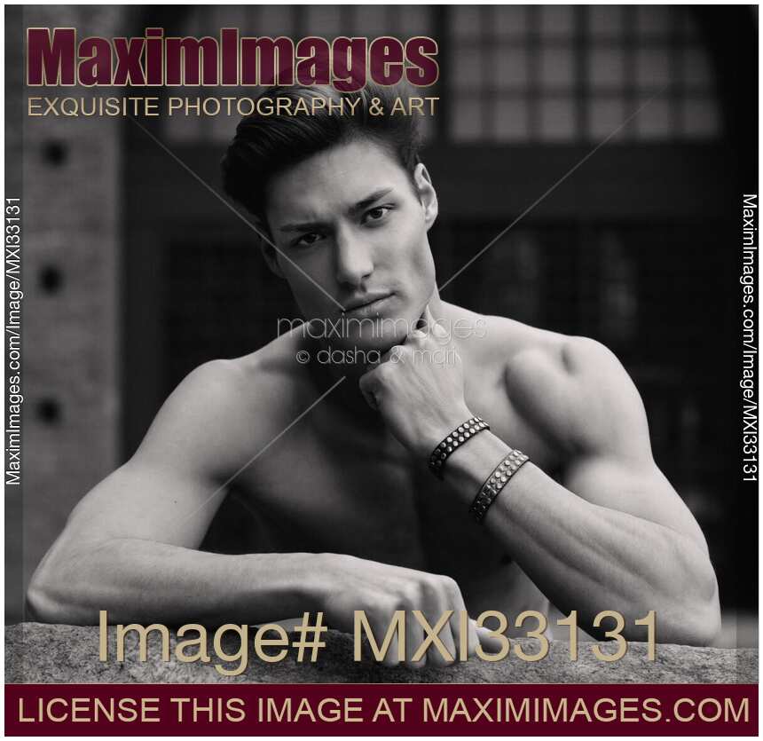 Expressive black and white portrait of a sexy handsome muscular man with a bare torso and stylish short hair