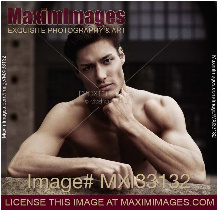 Expressive portrait of a sexy handsome muscular man with a bare torso and stylish short hair