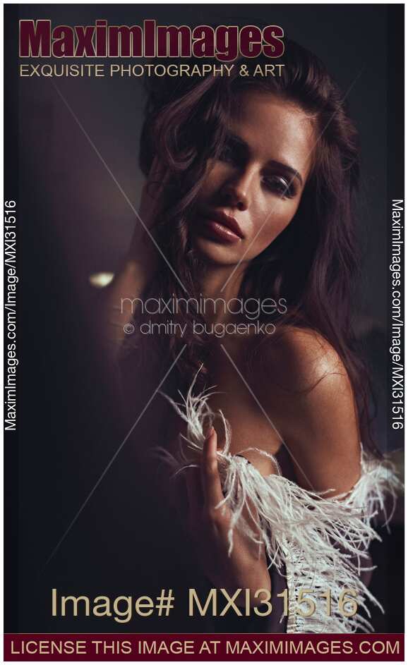 Expressive sensual portrait of a beautiful woman with feather boa around her bare shoulders