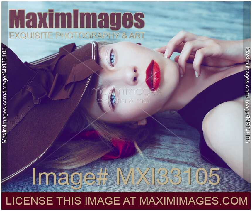 Extravagant beauty portrait of a lady in vintage hat with bright red lipstick