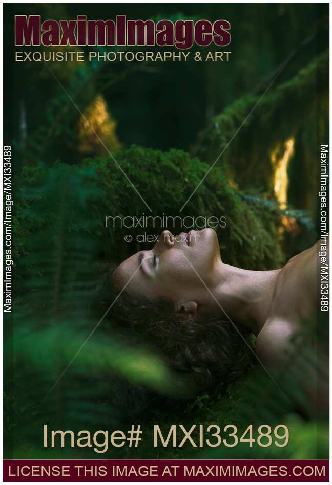 Face of a woman lying on green moss forest bathing, Shinrin-Yoku concept