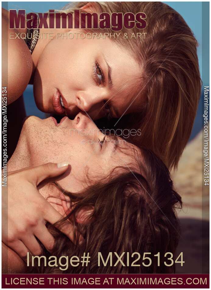 Faces of young couple kissing at the beach