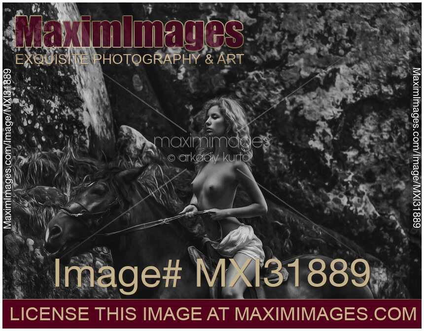 Fine art black and white photo of a naked young woman riding a horse