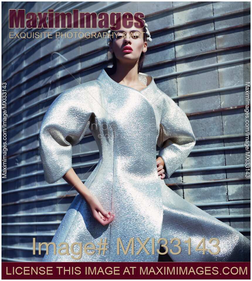 Futuristic high-fashion portrait of a woman with android doll look in a sci-fi fiction shiny metallic dress