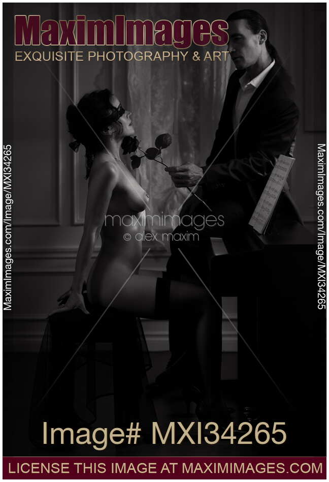 Gentleman caressing with a rose a gorgeous woman sitting at a piano naked and blindfolded. Black and white.