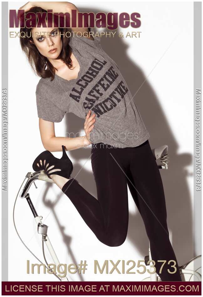 Girl in funny t-shirt posing with exercise bike
